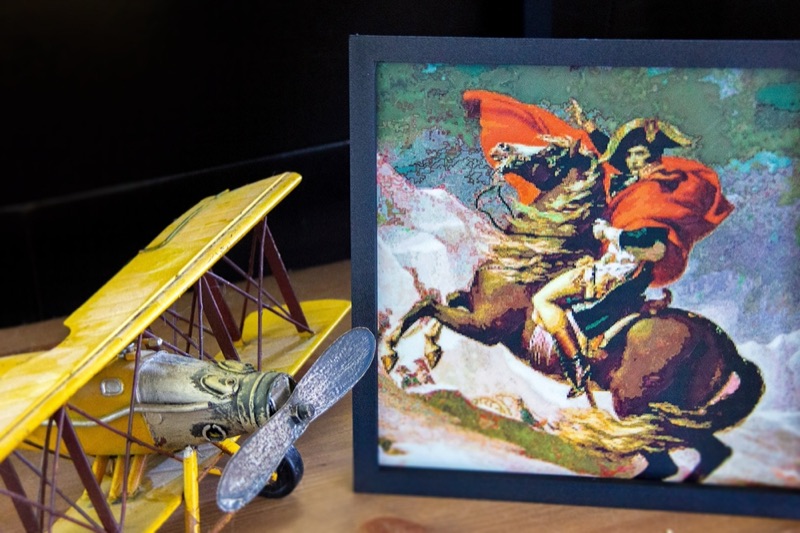 A framed Napoleon print beside a yellow model biplane