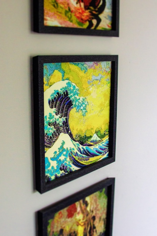 Three framed prints hung in a column on a wall